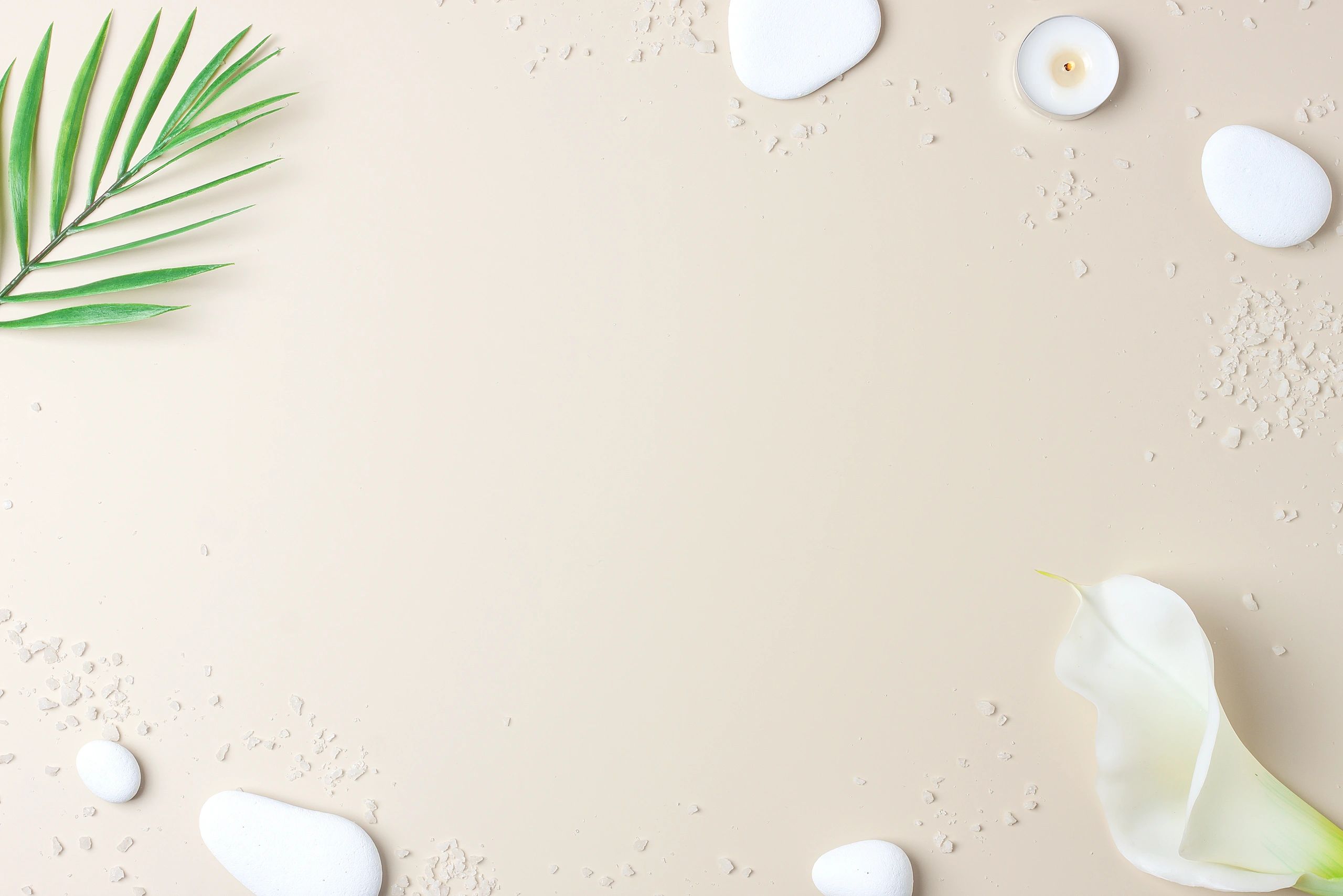 Neutral wellness flat lay with candles, stones, and botanical accents