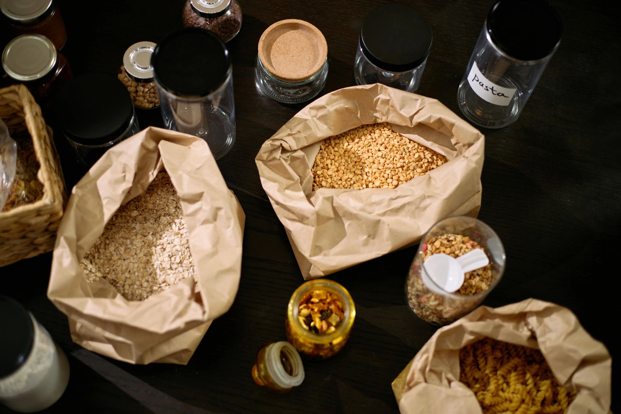 Assorted pantry ingredients arranged in paper bags and glass jars